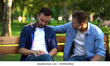 Young Male Supporting Friend Sitting Outdoors Together, Friendship Care, Advice