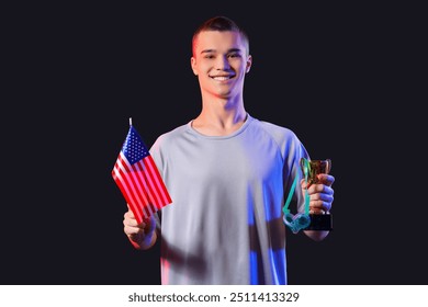 Young male swimmer with USA flag, golden cup and swimming goggles on black background - Powered by Shutterstock