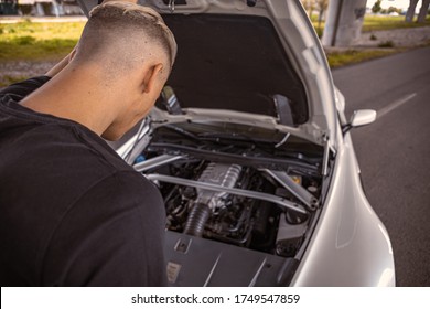 Young Male Taking A Look At His Car Engine With The Hood Popped