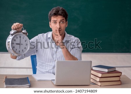 Young male teacher in time management concept