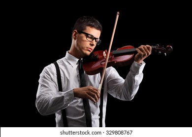 Young male violinist playing an acoustic violin on a black background