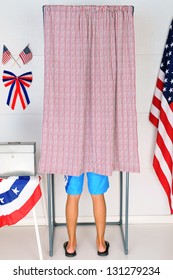 A Young Male Voter Inside A Voting Booth At His Local Polling Place. Vertical Format - Man Is Unrecognizable.