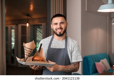 Young male waiter with dish in restaurant - Powered by Shutterstock