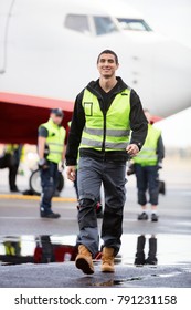 Young Male Worker Walking On Wet Runway At Airport
