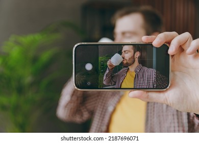 Young Man 20s He Wear Shirt Do Selfie Shot On Cell Phone With Cup Sit Alone At Table In Coffee Shop Cafe Relax Rest In Restaurant During Free Time Indoors. Freelance Mobile Office Business Concept.