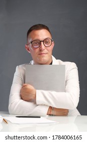 A Young Man Of 30-35 Years Old In A White Jacket, Black Turtleneck, Glasses And A Short Haircut Holds An Empty Sign In His Hands. Template For Design, Mockup.