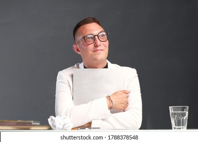 A Young Man Of 30-35 Years Old In A White Jacket, Black Turtleneck, Glasses And A Short Haircut Holds An Empty Sign In His Hands. Template For Design, Mockup.