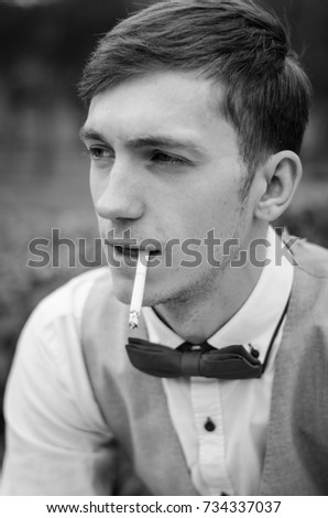 Similar – young guy in a shirt smokes on the street