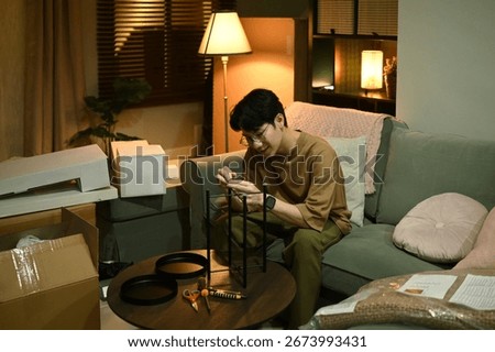 Young man adding final touches to the shelf by installing protective pads, Protective Furniture Assembly Step at Home.