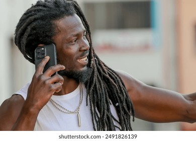 young man with afro hair or dreadlocks talking on mobile phone on the street - Powered by Shutterstock