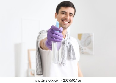 Young Man With Air Freshener At Home