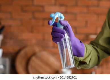 Young Man With Air Freshener In Kitchen