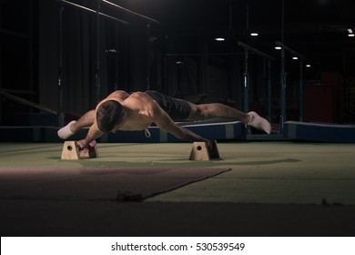 Young Man, In Air, Gymnast, Two Hands Cartwheel. Indoors, Dark Hall.