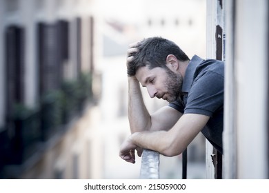 Young Man Alone Outside At House Balcony Terrace Looking Depressed, Destroyed, Wasted And Sad Suffering Emotional Crisis And Depression On Urban Background 