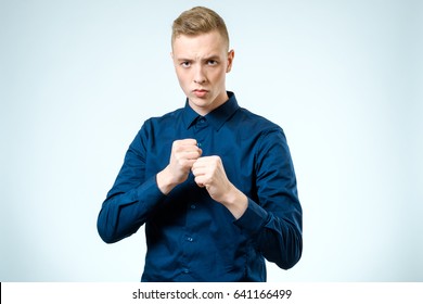 Young Man Angry Gesturing Fist Raised On Isolated White Background