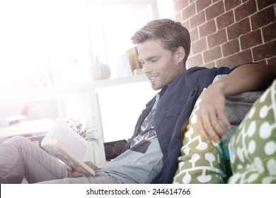 Young Man In Apartment Reading Book