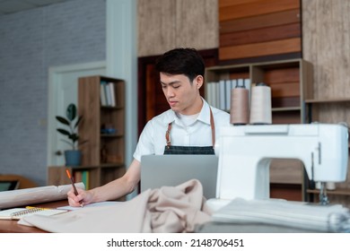 Young Man Asian LGBTQ Tailor Shop Owner,Close-up Of The Stern Face Of A Technician Who Is Designing A Bespoke Outfit,Small Business Professional Design Clothes To Sell Online.