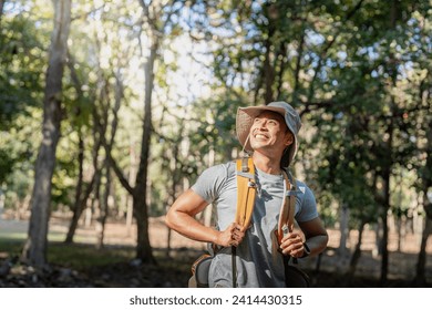 Young man asian trekking among trees with backpack, young man enjoy alone in forest. Camping, hiking, travelling, search for adventure concept - Powered by Shutterstock