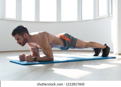Young Man Athlete Doing Abs Exercise Elbow Plank As Part Of Bodybuilding Training