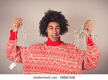 Young man attempts to untangle a string of Christmas lights