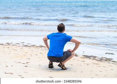 Young Man Back Squatting Crouching Sitting On Beach Bay Shore Sand In Florida Near Pensacola