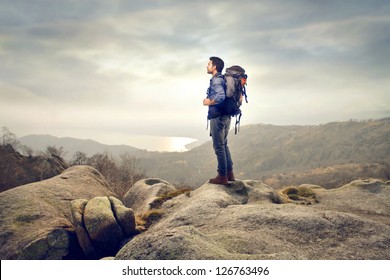 Young Man With Backpack Hiking In The Mountains