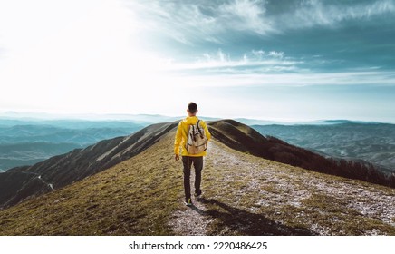 Young man with backpack hiking mountains - Hiker having trekking day out on a sunny day - Successful, sport and inspirational concept - Shutterstock ID 2220486425