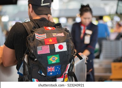 Young man with backpack in international airport at check-in counter for travel around the world.