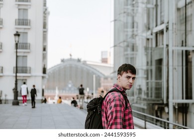 Young Man With Backpack Standing in Front of Building