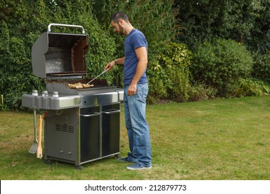 Young Man At A Barbecue Grill