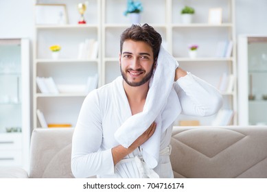 Young Man In A Bathrobe After Shower Drying Hair With A Towel