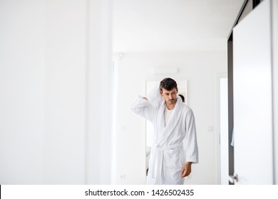 Young Man With Bathrobe In The Bedroom, A Morning Routine.