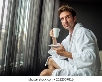 Young Man In Bathrobe Drinking Coffee At Home