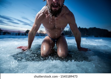 Young man with beard swims in the winter lake