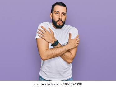 Young Man With Beard Wearing Casual White T Shirt Shaking And Freezing For Winter Cold With Sad And Shock Expression On Face 