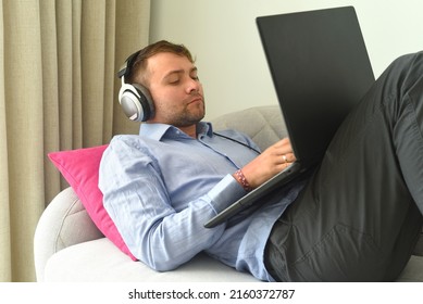 Young Man Beat Maker Working From Home With His Laptop Laying On Couch