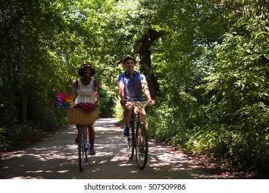 un joven y una hermosa joven afroamericana disfrutando de un paseo en bicicleta por la naturaleza en un soleado día de verano
