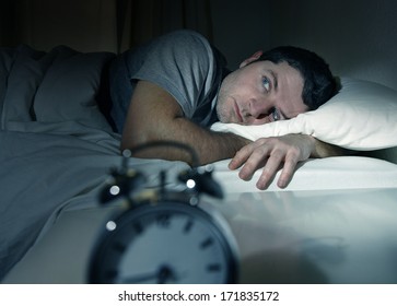young man in bed with eyes opened suffering insomnia and sleep disorder thinking about his problem - Shutterstock ID 171835172