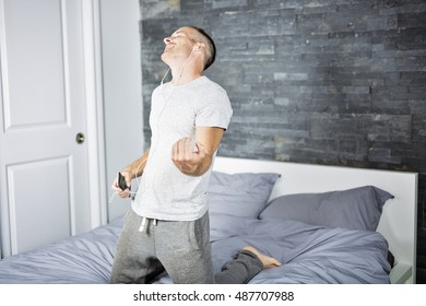 A Young Man In Bed Playing Air Guitar