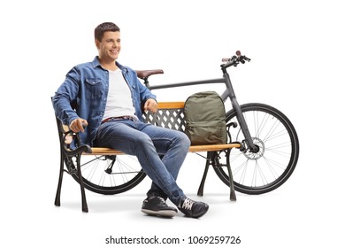Young man with a bicycle and a backpack sitting on a bench isolated on white background