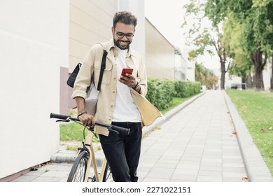 Young man with bicycle looking at smartphone in a city - Powered by Shutterstock