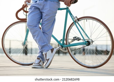Young man with bicycle on embankment - Shutterstock ID 2120682698