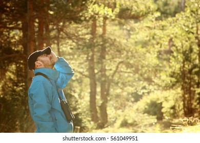 A Young Man Birdwatching In The Forest Early Morning