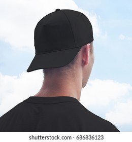 Young Man In A Black Cap And T-shirt. Black Baseball Cap Mockup. Close-up