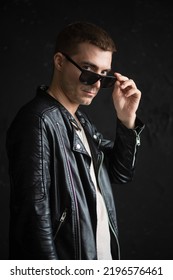 A Young Man In Black Leather Jacket And Black Sunglasses Close Up Portrait.