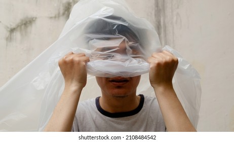 Young Man with a black plastic bag on his head. suffocate