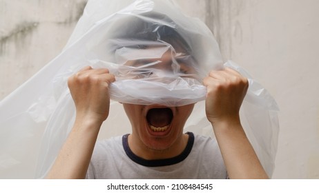 Young Man with a black plastic bag on his head. suffocate