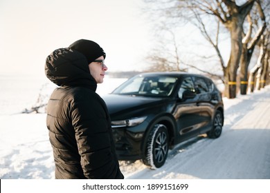 
Young Man In Black Stands Next To Broken Car On Winter Road, Waiting For Help. Broken Car, Accident Concept.