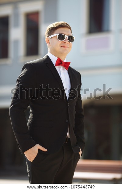 black dress shirt with red bow tie