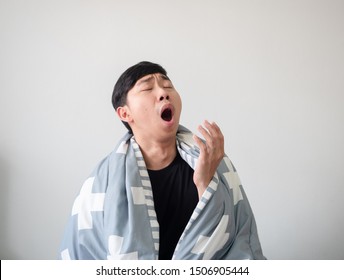 Young Man With Blanket Cover His Body Wake Up And Feel Sleepy And Yawn On White Isolated,Sleepy Man Concept